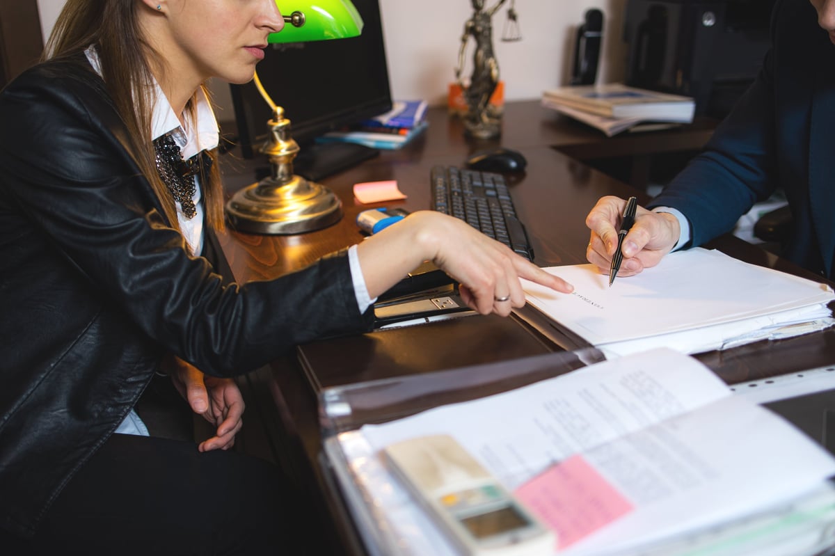 Attorney explaining a lease agreement to clients in an office