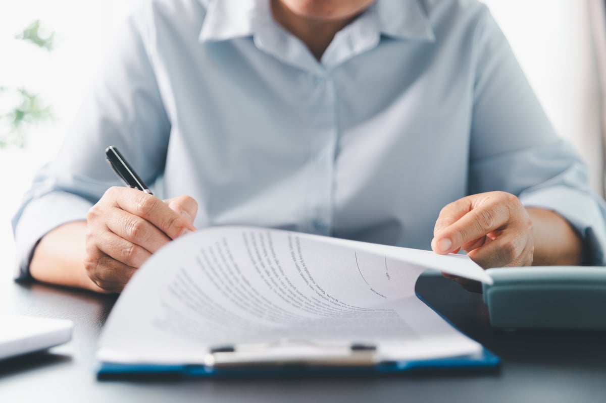 Legal professional signing a contract at a desk